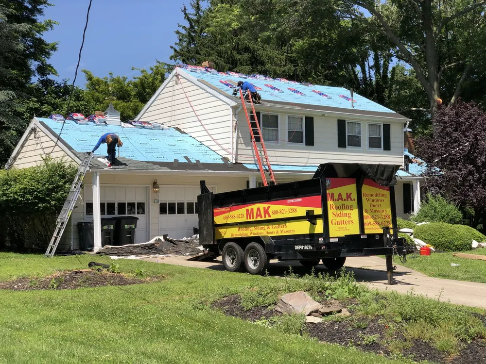 Crew installing a new shingle roof