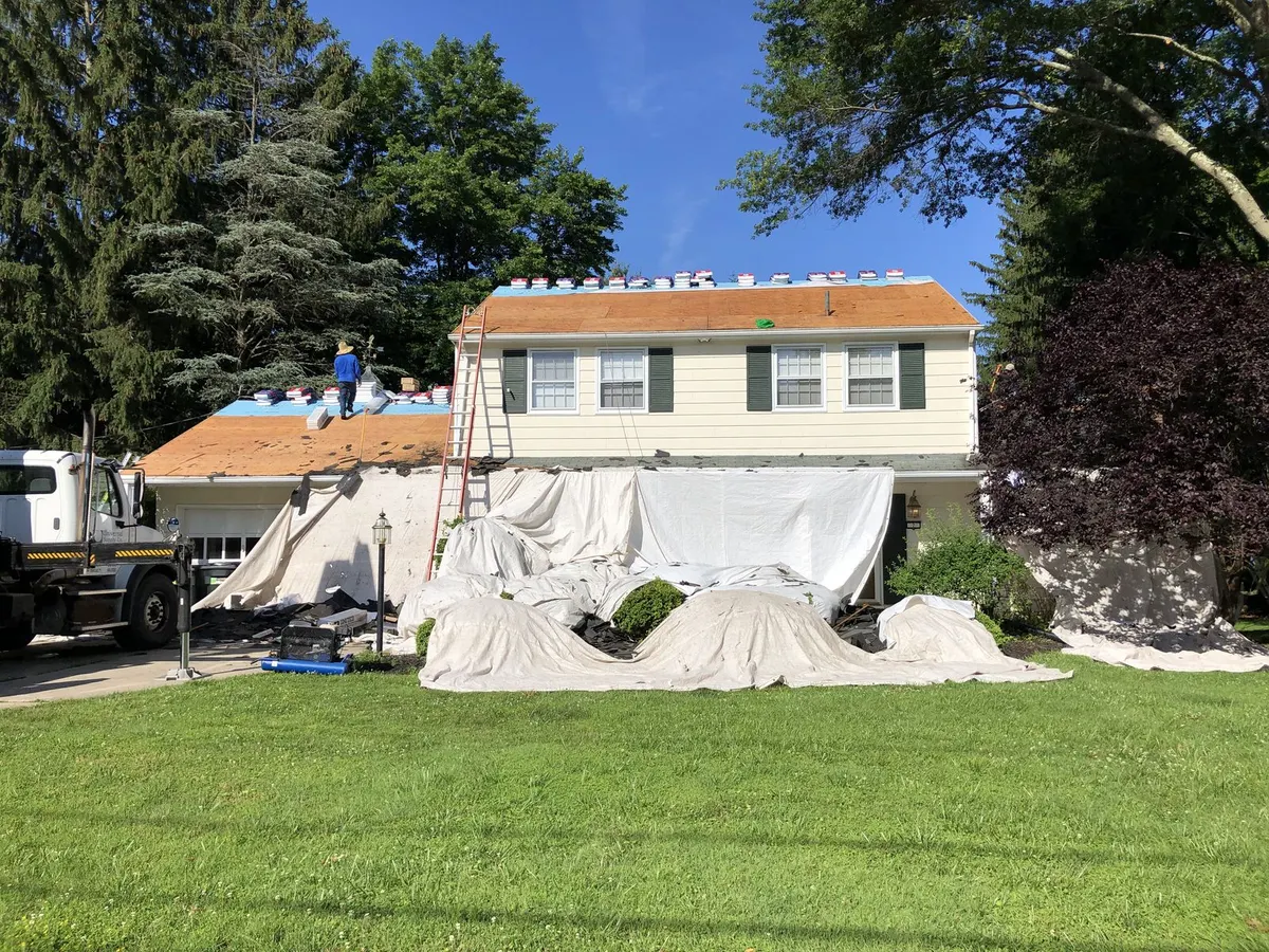 House mid roof replacement with protective tarps