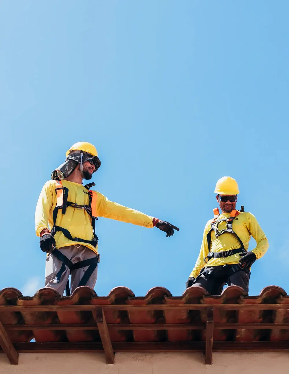 Roofer in safety gear on a tile roof